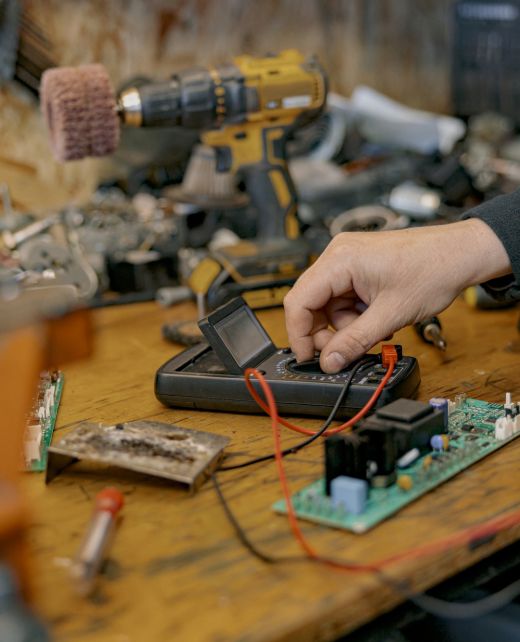 Close up of electrician hands checks the electrical voltage on the circuit board with a Close up of electrician hands checks the electrical voltage on the circuit board with a